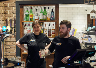 Members of Gosforth Civic Theatre staff in uniform tops working at the bar.