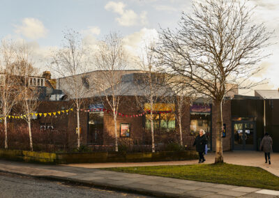 A view of Gosforth Civic Theatre from outside, including some smaller trees and a patch of grass